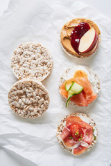 Variation of healthy gluten free rice cakes with fruit, vegetables, meat, salmon and sweets viewed from above. Top view