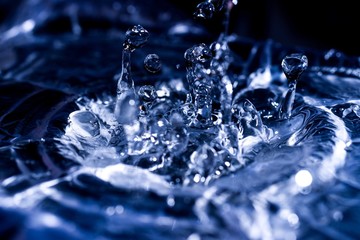 Water drops splashing on acoustic membrane. A lot of drops in air. High frequency of sound waves. Water cloud small drops. Frozen time shot.