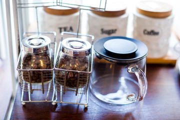 coffee bean and tea with sugar in a glass jar on wooden table