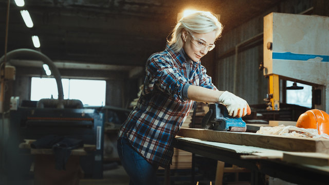 Active middle aged woman selects wood in workshop. Concept of professionally oriented motivated modern woman. Gender equality, image of femininity