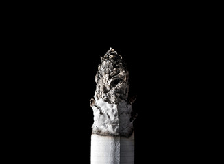 Burning smoldering smoking cigarette close-up isolated on black background