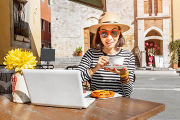 Happy asian freelancer woman ic casual clothes working with laptop pc in outdoors cafe