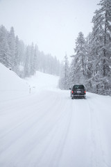 Van driving along snowcapped mountain road