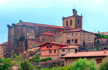 Fototapeta na wymiar Vinuesa with its Romanesque church on a sunny day. It is a town in the province of Soria in Spain.
