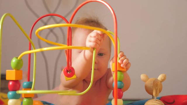 Playing and learning. Fine motor skills developing. Wish list for toddlers, babies. Colorful toy appealing to hold. Montessori background. Toddler developing fine motor skills.