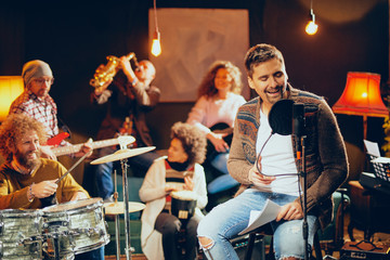 Multicultural band practicing for the gig. Home studio interior.