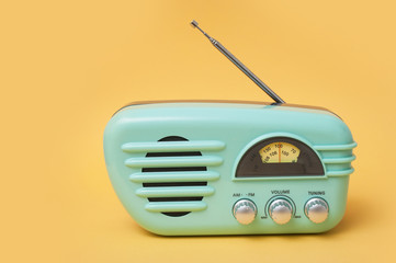 closeup of vintage fifties style radio on yellow background