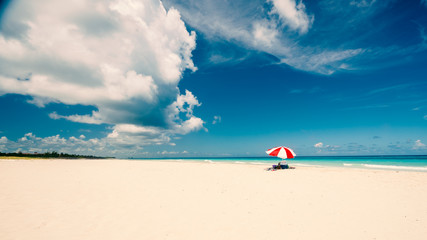 Awesome beach of Varadero during a sunny day, fine white sand and turquoise and green Caribbean sea,on the right one red parasol,Cuba.concept  photo,copy space,vintage style.