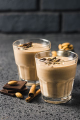 Chocolate almond milk oat smoothie on dark background. Selective focus, space for text.