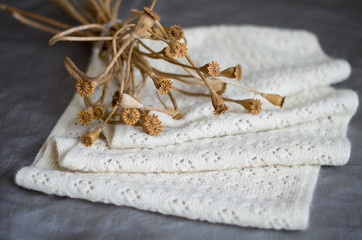 Knitted white scarf on grey surface
