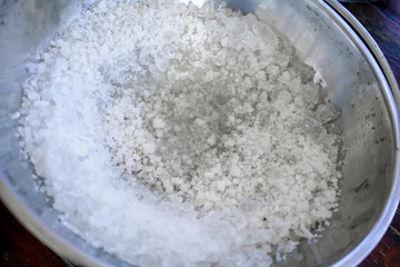 Crushed ice mixed with salt in stainless bowl prepared for making homemade ice cream.