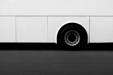 Side view of a white bus wheel on an asphalt road. - copy space for background.