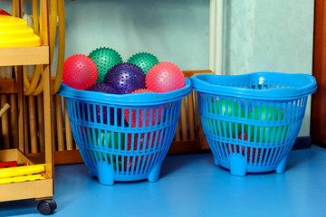 Hall for physical education in kindergarten. Multi-colored balls lie in plastic boxes