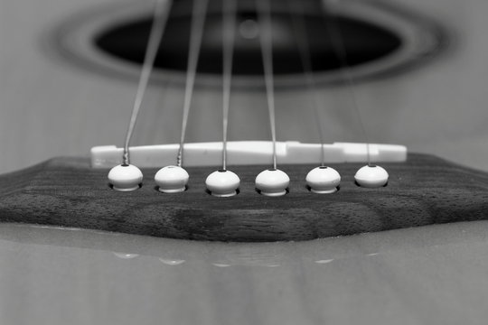 A black and white image of a 6 string, flattop guitar.