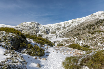 Fototapeta na wymiar Way of ascent to the lagoons of Peñalara in the mountain range of Madrid covered by snow.