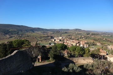 Fototapeta na wymiar Walls of Rocca di Montestaffoli fortress with tuscany landscape on the background, San Gimignano, Italy