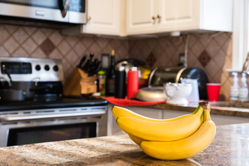 Interior of a kitchen with a bunch of bananas on the foreground © Nickolay Khoroshkov