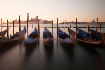 Venice classic sunrise view with gondolas on the waves