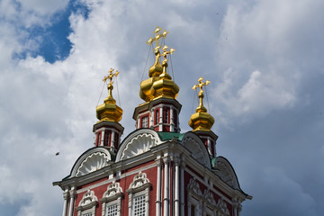 Fototapeta na wymiar Beautiful building of the Russian Orthodox Church. Covered in gold dome. Crosses and exterior decoration. Love to God