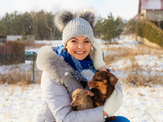 Woman playing with dogs during winter