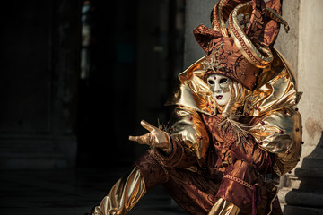 Gesturing person in Venetian carnival costume of Harlequin