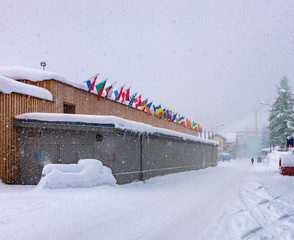 International flags on the roof of Congress building at snow fall  in Davos, Switzerland.