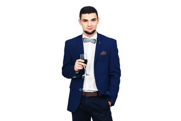 Obraz na płótnie Canvas young stylish man in blue suit posing with a glass of wine