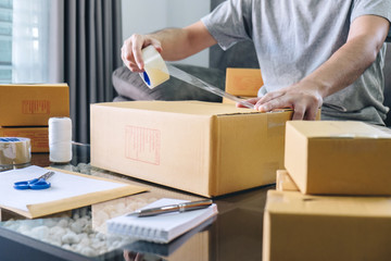 Small business parcel for shipment to client, Young entrepreneur SME freelance man working with packaging their packages box delivery online market on purchase order and preparing package product