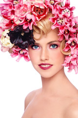 Fototapeta premium Young beautiful smiling girl with fancy make-up and colorful flowers in her hair