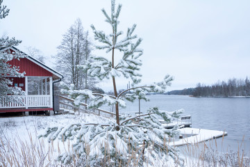 Red house at beautiful river Kymijoki in winter. Kouvola, Finland.