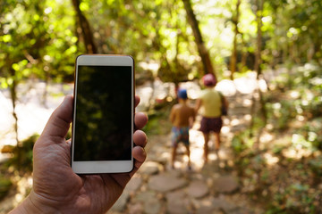 mobile phone in a hand in jungle