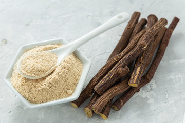 Powder and licorice root on the table - Glycyrrhiza glabra