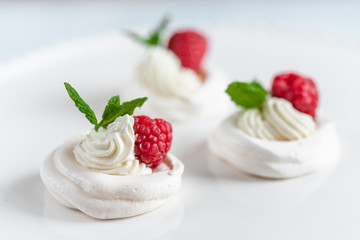 Obraz na płótnie Canvas Mini Pavlova meringue with whipped cream and raspberries.