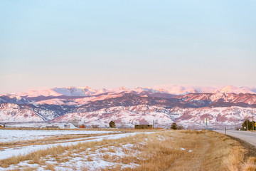 beautiful colorado sunrise with snow capped mountains and blue skies at the foothills of the rocky mountains © Austin
