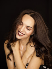 Naklejka premium Portrait of very attractive tender young dark haired woman with fashion makeup and wet skin effect on black background