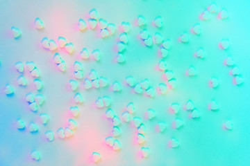Background with heart shaped sugar candies in modern colors cyan and pink. Soft focus. Love and health concept.
