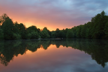 Fototapeta na wymiar Sunrise reflection on the Lake. Burger lake. Tree near the lake. Symmetrical refflection.