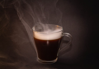 the concept of really hot coffee with cream on a dark isolated background