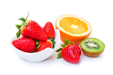ripe strawberries in a plate orange and kiwi on a white background