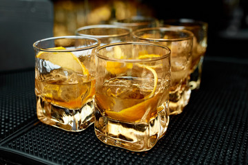 Alcoholic cocktails whiskey with orange peel in glasses 