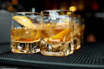 Alcoholic cocktails whiskey with orange peel in glasses 
