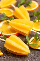 Homemade orange popsicle with ripe orange and fresh mint