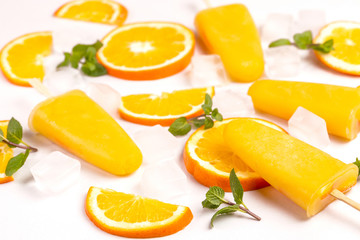 Homemade orange popsicle with ripe orange and fresh mint