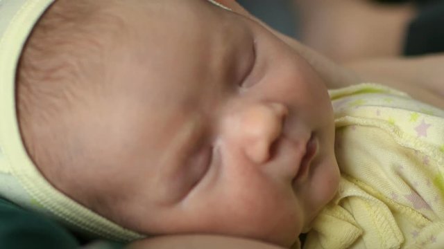 Newborn baby portrait lie on mother chest at home in hat