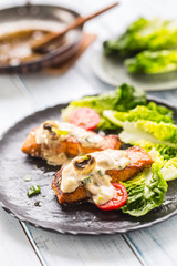 Delicious grilled roasted salmon fillets or steaks with mushroom sauce sesame tomatoes and lettuce salad