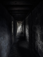 Obraz premium Ancient corridor with beams of light. Dark hallway in a medieval building.