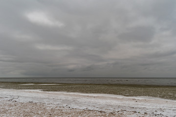 Snowy seashore. View of the horizon, on a cold winter evening.