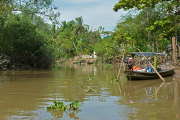 An old wooden boat moored at the side of a waterway outside the city of Can Tho in the Vietnam Mekong Delta