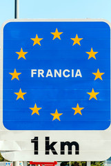 Poster indicating one kilometer distance between Spain and France on the border in Catalonia