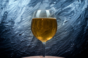 Yellow beer close up shot .Pouring beer with bubbles and foam in glass dark background.